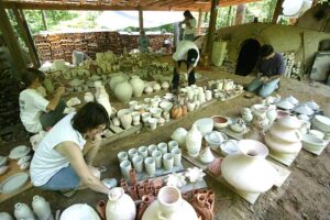 Applying fireclay wads to the pots before loading